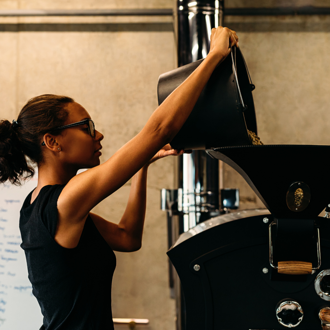 Woman coffee roaster. Black woman roasting coffee